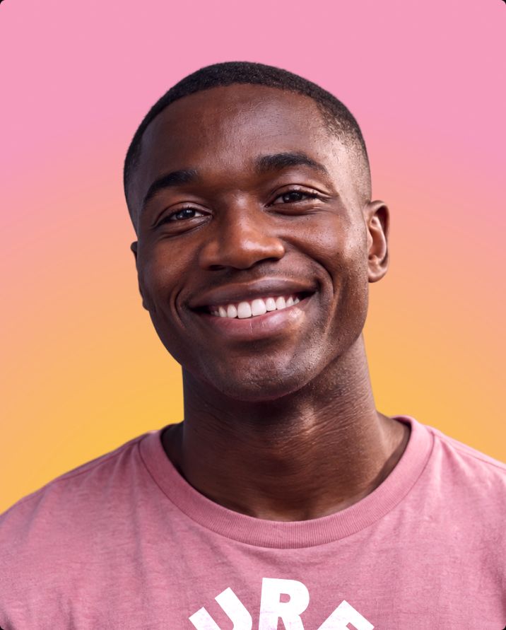 Smiling man in a pink t-shirt on a pink-to-orange gradient