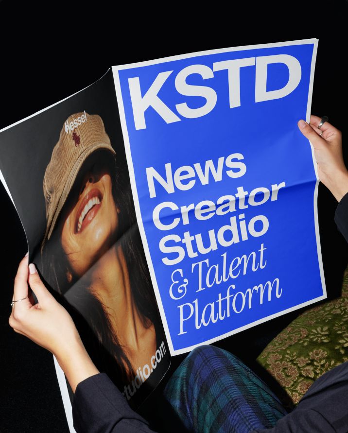 Person reading a KSTD broadsheet: News Creator Studio & Talent Platform