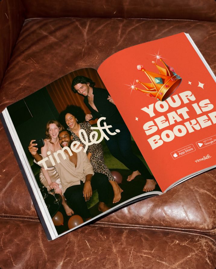 Open magazine with a Timeleft double-page ad on a leather sofa