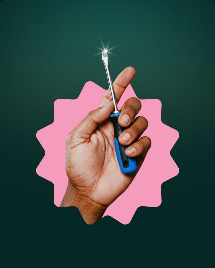 Hand holding a screwdriver on a pink starburst sticker