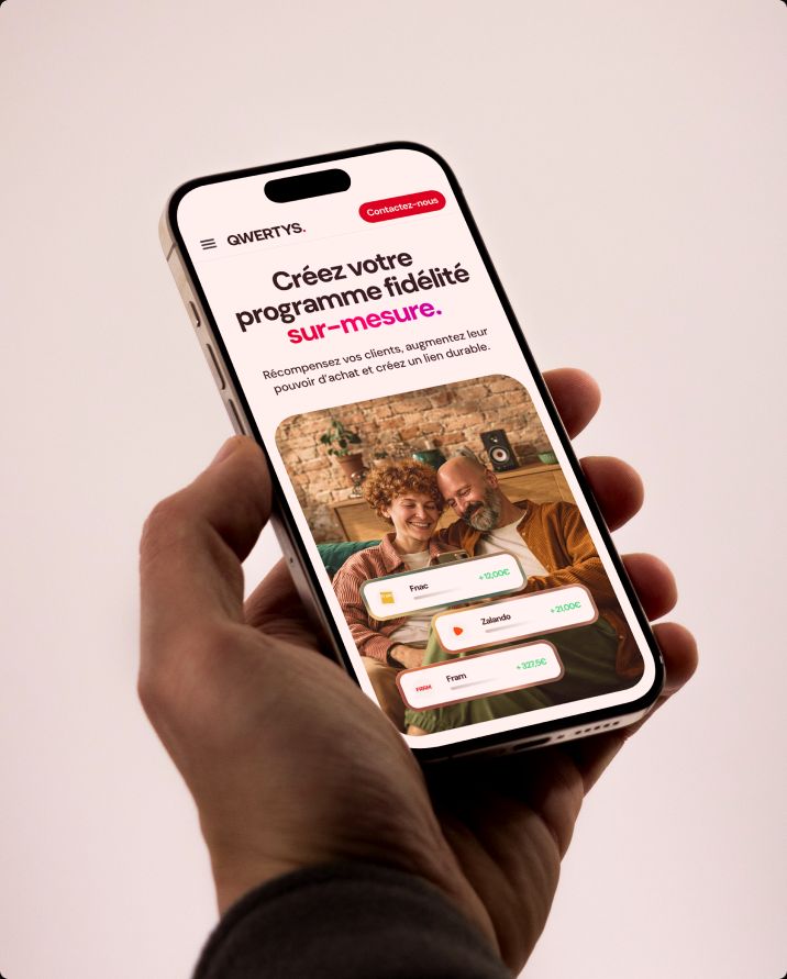 Hand holding a phone with the Qwertys mobile website