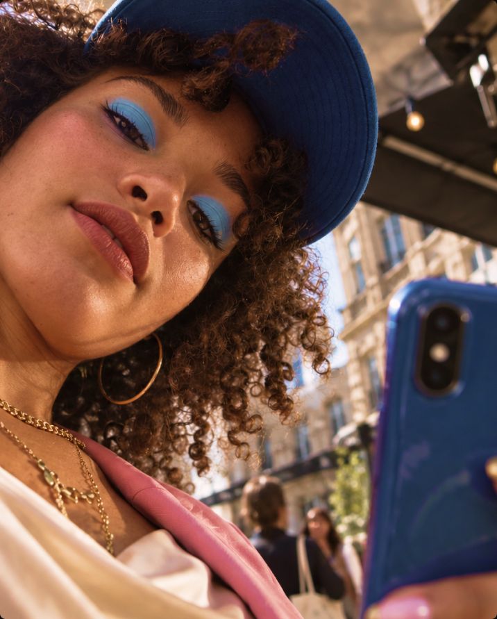 Young woman looking at her phone in the street